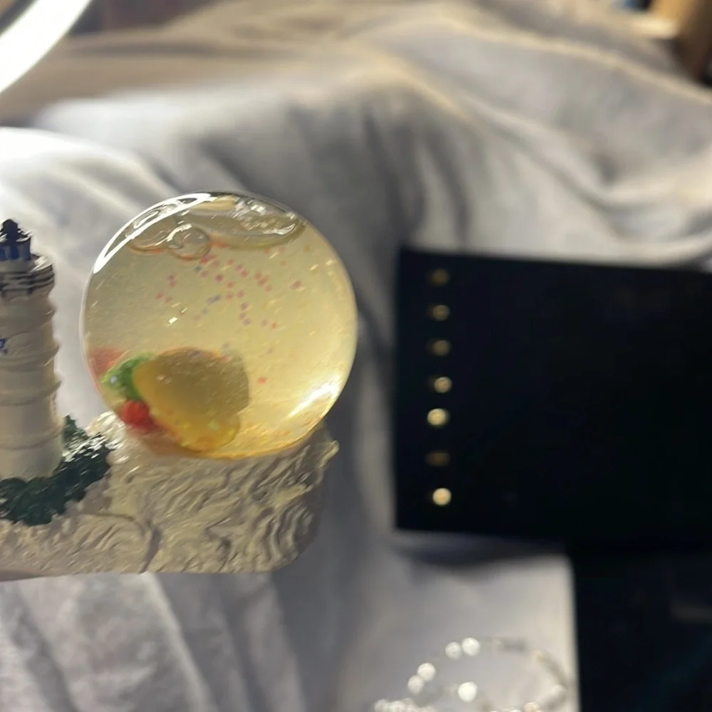 Small Snow Globe Lighthouse w/red roof house-color is clouded Santa is a floater